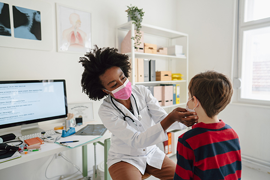 Doctor examining young boys throat