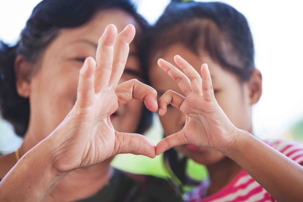 grandma child making heart shape hands