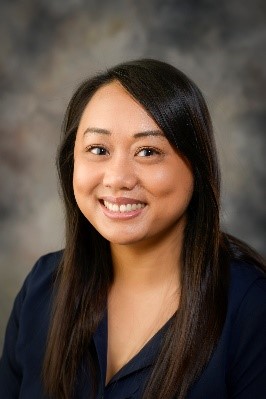 A person smiling in front of a treeDescription automatically generated